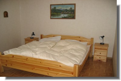 Gro�es helles Doppelbettzimmer mit antikem Schrank und Tisch